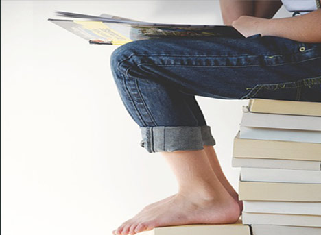 Lissone - ragazza a piedi nudi seduta su una pila di libri